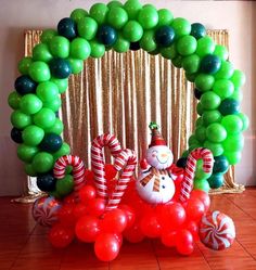 a balloon arch decorated with candy canes and snowman