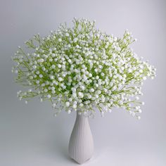 a white vase filled with flowers on top of a table