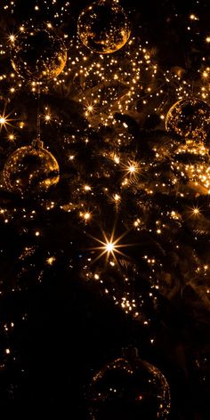 many shiny balls in the dark with lights shining on them and stars all around it