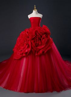 Dreaming of a prom dress thatas fiery as your spirit? Don this breathtaking red gown and ignite the night with your presence. The strapless bodice is sleek and fitted, offering a smooth canvas that contrasts with the extravagant tulle skirt. Embellished with oversized rosettes, reminiscent of a garden in midsummer bloom, the skirt brings a dramatic flair to this sartorial masterpiece. As you move, the layers of tulle create an enchanting flow, ensuring that with every step, you're not just walking; you're performing a ballet of elegance and poise. This dress is a celebration of passion and confidence, a perfect reflection of your most unforgettable moments. Quinceanera Dresses Red, डिजाइनर कपड़े, Red Ball Gown, Pink Ball Gown, Tulle Party Dress, Long Train Wedding Dress, Strapless Evening Dress, Strapless Prom Dresses, Prom Ball Gown