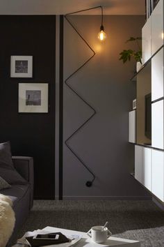 a modern living room with grey walls and white furniture, including a gray sectional sofa