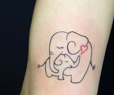 an elephant with a heart tattoo on its leg is holding a baby elephant in it's trunk