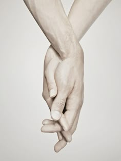 two hands holding each other in front of a white background