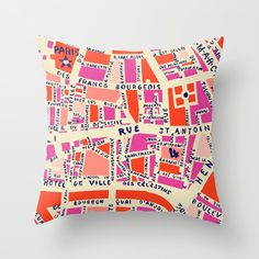 an orange and pink pillow with words all over it on a white background, in the shape of a city map