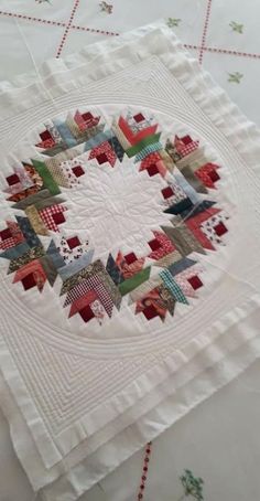 a quilted table cloth with red, green and white squares in the shape of houses