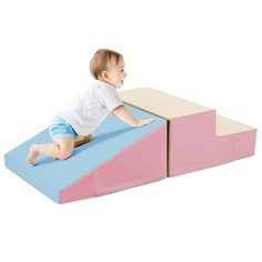 a baby sitting on top of a pink and blue ramp