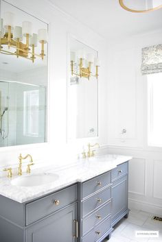 a bathroom with two sinks and mirrors in the corner, along with gold faucets