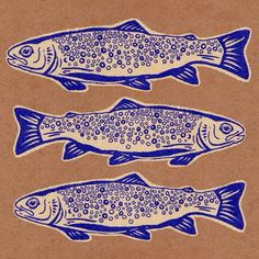 three fish on brown paper with blue inking in the shape of dots and circles