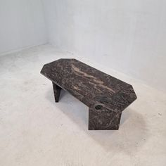 a black marble bench sitting on top of a white floor