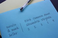 a blue piece of paper sitting on top of a desk next to a pen and calculator