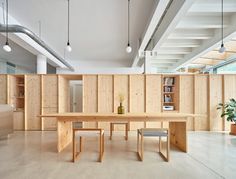 a large wooden table sitting in the middle of a room with lots of bookshelves