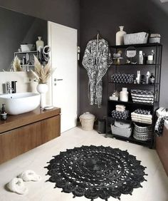 a bathroom with black and white decor on the walls, rugs and sink area