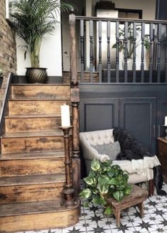 a living room filled with furniture next to a stair case and potted plant on top of a wooden table