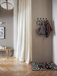 a living room with wood floors and white curtains