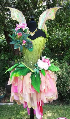 a mannequin dressed in pink, green and yellow with flowers on it's head