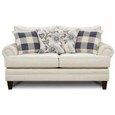 a white couch with pillows on it and some blue flowers in the pillow case,