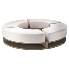 the circular couch is made from white fabric and has two sections on each side that are connected