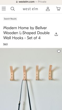 the wooden hooks are hanging on the wall and there is also a leather handbag