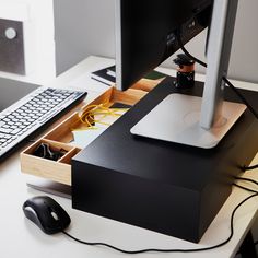 a computer monitor sitting on top of a white desk next to a keyboard and mouse