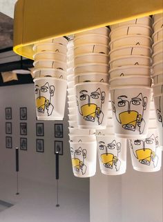 cups with faces drawn on them hanging from the ceiling