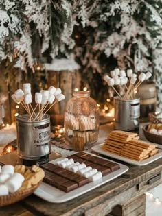 a table with marshmallows, cookies and hot chocolate on it