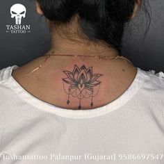 a woman's back neck with a tattoo design on the upper part of her chest