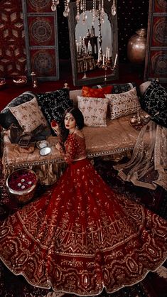 a woman in a red dress sitting on a couch