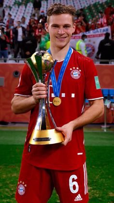 a soccer player is holding up the trophy