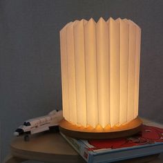 a lamp sitting on top of a table next to a book