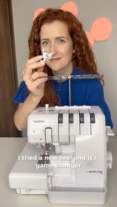 a woman holding up a sewing machine with the words i tried a new tool and it's game changer