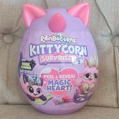 an egg shaped like a cat with pink ears on it's head and the words kittycorn surprise inside