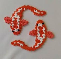 two orange and white beaded animal brooches