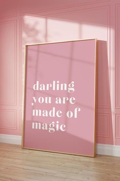 a pink poster with the words daring you are made of magic on it in front of a pink wall