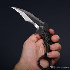 a person holding a knife in their hand with the blade still attached to it, on a black background