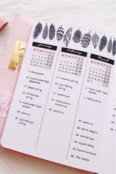 a pink planner with black and white leaves on it, next to a gold bar