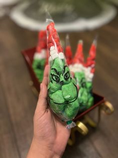 a hand holding some candy in the shape of grin face on top of a sleigh