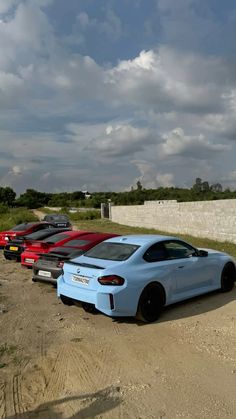 four different colored cars parked in a row