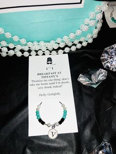 a necklace and bracelet on display with some other items in front of it's packaging