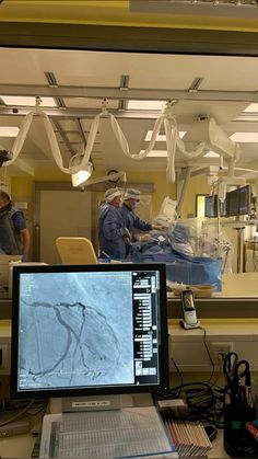 two doctors in the operating room looking at an image