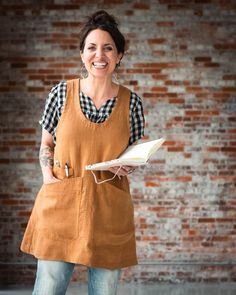 a woman in an apron holding a book