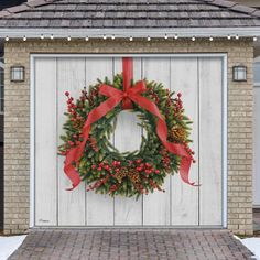 a christmas wreath is hung on the side of a garage door with a red ribbon