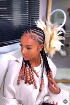 a woman with long braids sitting on a couch