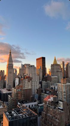 the city skyline at sunset with tall buildings and skyscrapers in the foreground, as seen from an elevated rooftop