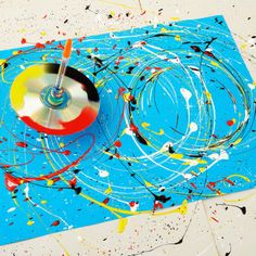 a painting with paint splatters on it and a spinning disc in the middle