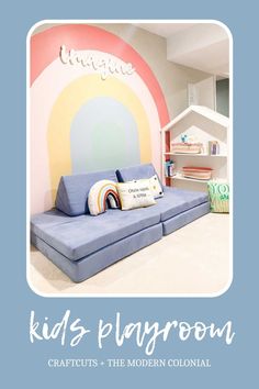 a kid's playroom with a blue couch and rainbow painted on the wall