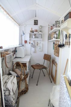 a room filled with lots of furniture next to a white counter and shelves on the wall