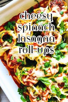 a white plate topped with pasta covered in cheese and spinach lasagna roll ups