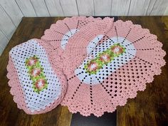 three crocheted doily on top of a wooden table