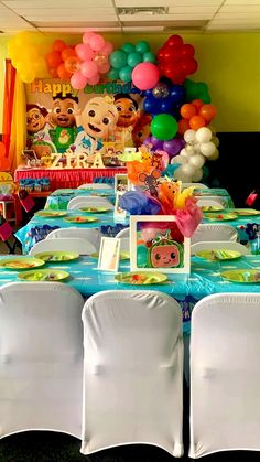 a table set up for a children's birthday party with balloons and other decorations