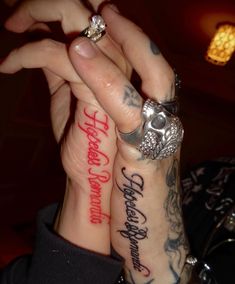 two people with tattoos on their arms holding each other's hands